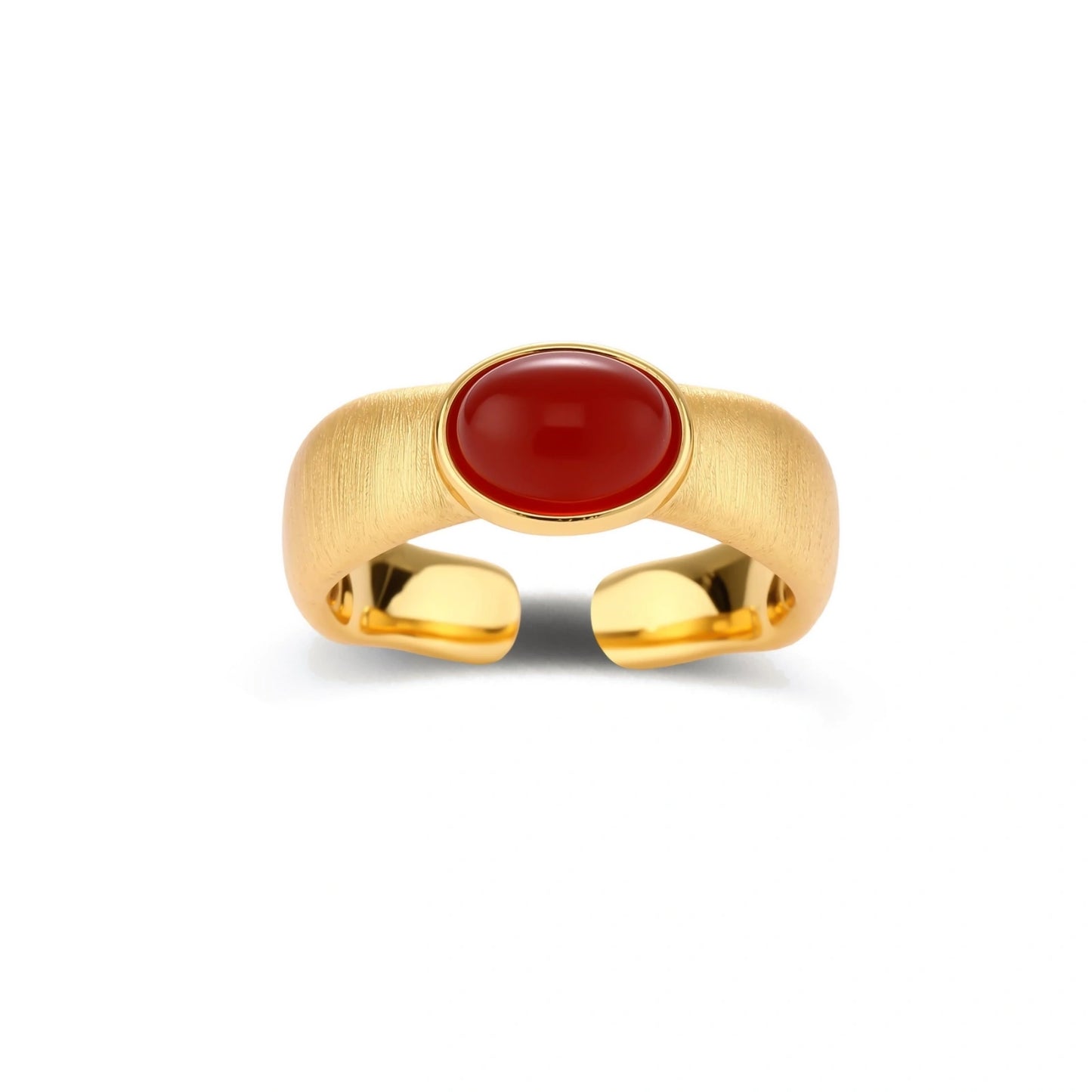 Close-up of brushed gold-plated ring with deep red oval stone, featuring adjustable band design on neutral background.