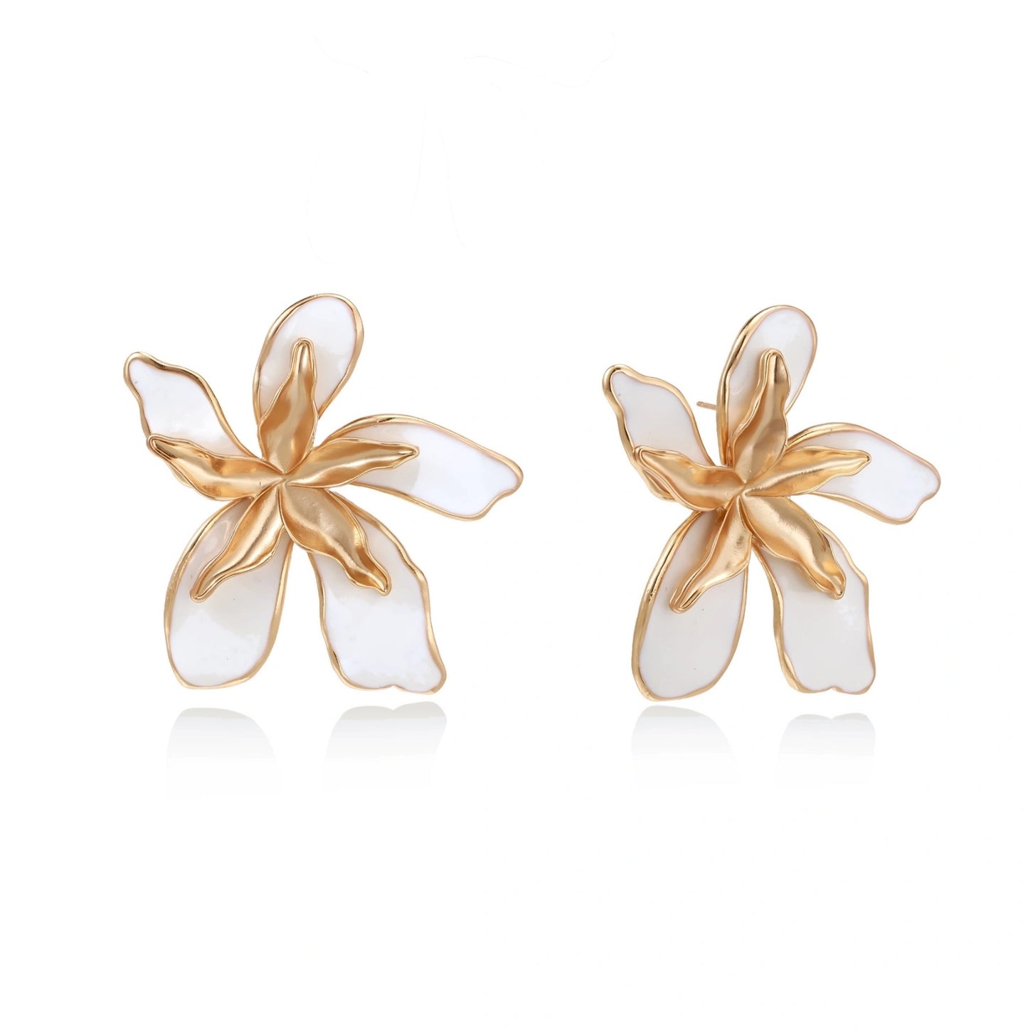 White enamel tropical flower earrings with sculptural gold-plated center and organic petal design on cream background