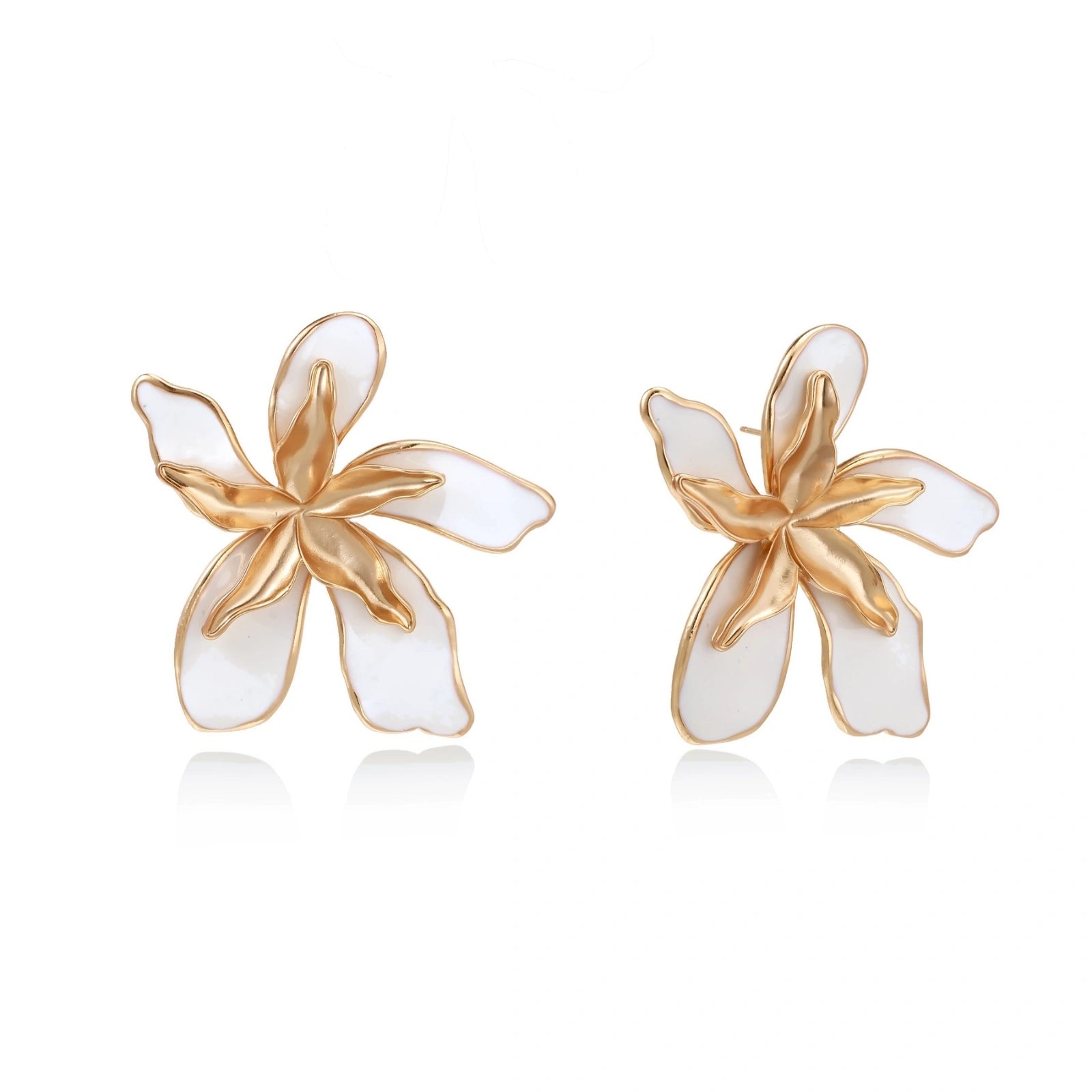 White enamel tropical flower earrings with sculptural gold-plated center and organic petal design on cream background