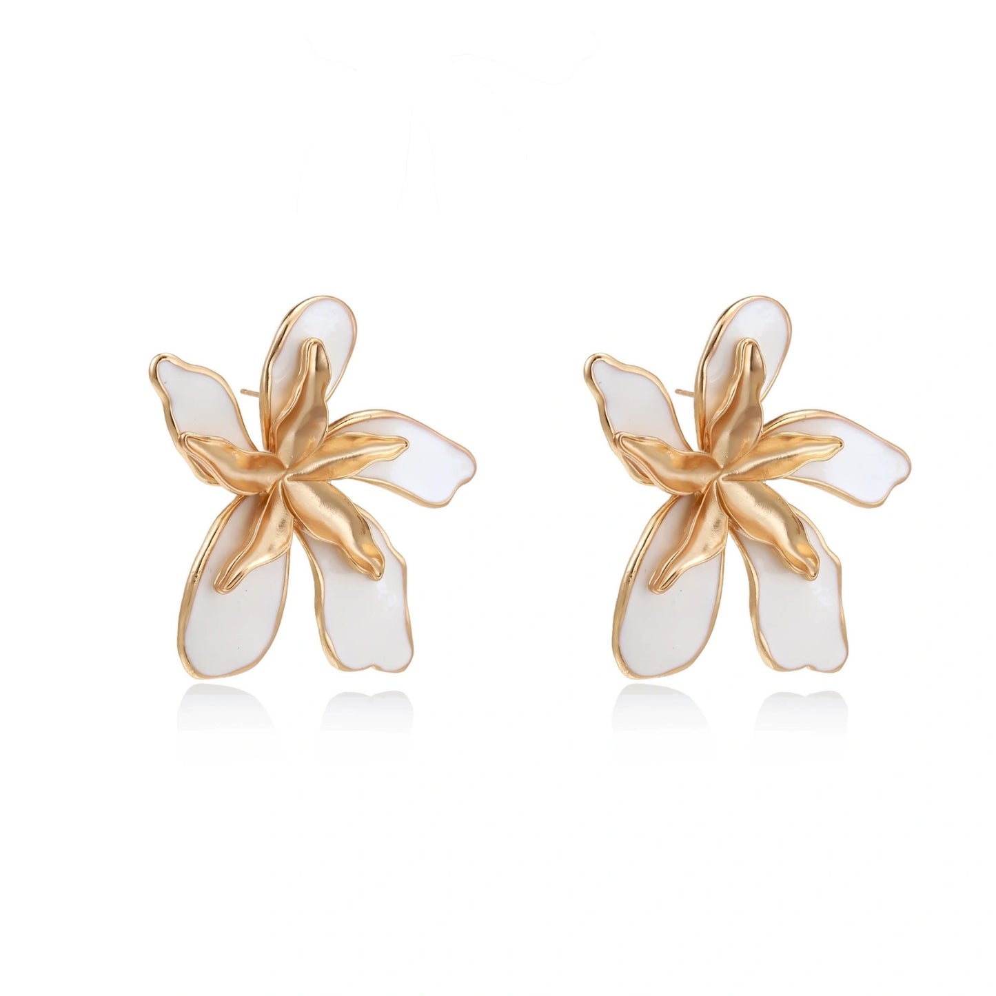 White enamel tropical flower earrings with sculptural gold-plated center and organic petal design on cream background