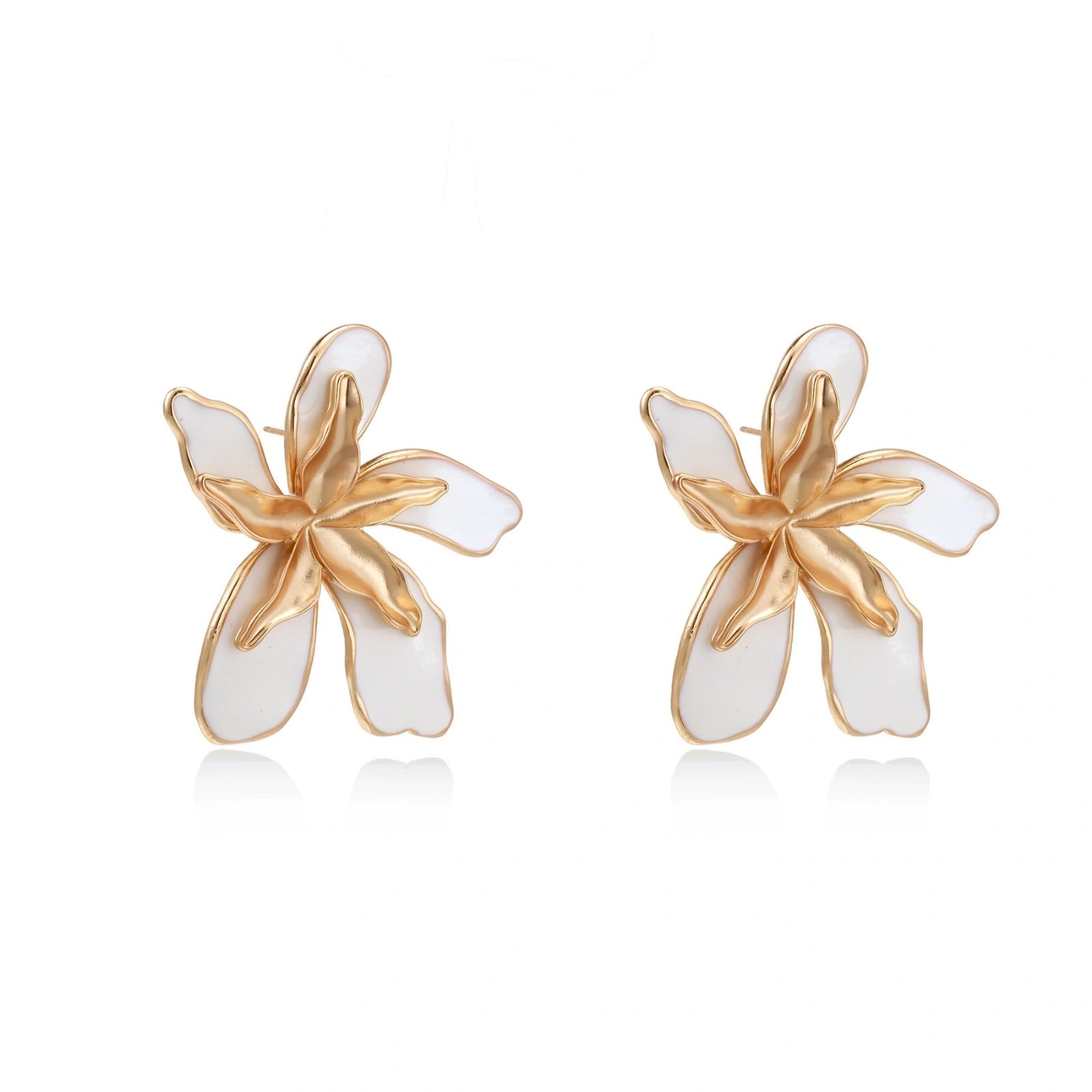 White enamel tropical flower earrings with sculptural gold-plated center and organic petal design on cream background