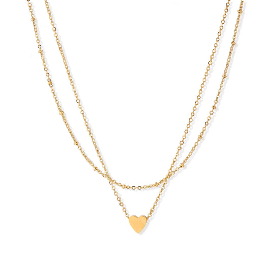 Delicate double-chain gold necklace with tiny heart pendant on cream background
