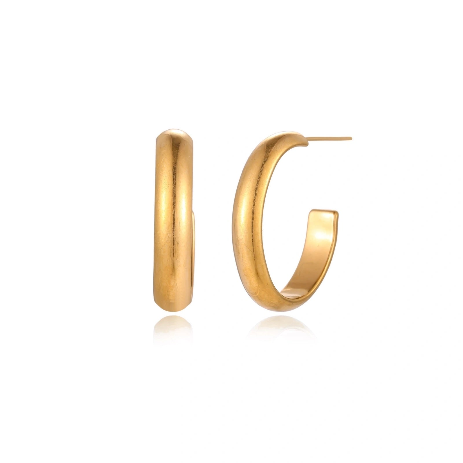 Chunky tubular hoop earrings in warm 14K gold-plated finish with smooth polished surface on cream background.