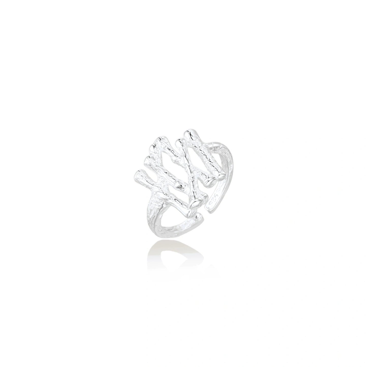 Sculptural sterling silver ring with organic branch design and textured surfaces on cream background