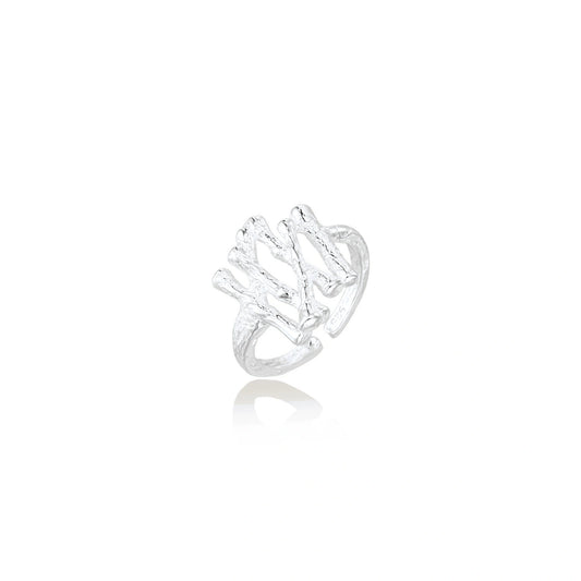 Sculptural sterling silver ring with organic branch design and textured surfaces on cream background